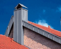 Abgestuftes Dach mit Blecheinfassung und zwei Schornsteinen 