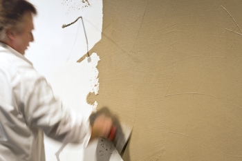 Handwerker verputzt eine Wand