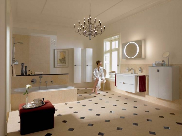 Frau in weißem Bademantel sitzend aus dem Fenster blickend in einem Badezimmer, Spiegel, Waschtisch, Badewanne, Dusche, Bademöbe