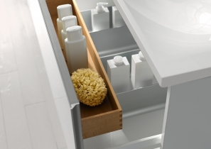 Weißes Badschränkchen der Serie Royal Reflex von Keuco mit geöffneter Schublade und eingehängter Buchenholzbox